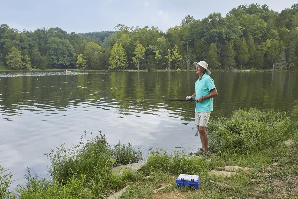 Kentucky bank angler watching cloud cover move across a summer lake while comparing shallow cover with nearby deeper water.